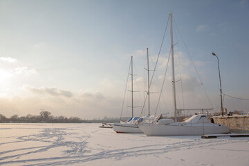 Winter landscape with a yacht on a frozen lake 