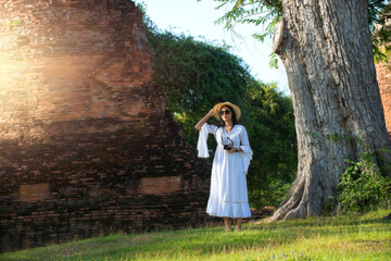 Portrait women in white Dress  travel in Ancient temples Ayutthaya, Thailand.