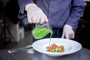 closeup of cream spinach soup with bacon on gray marble on a white plate