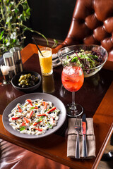 Gourmet Stracciatella cheese with strawberry, balsamic, mint salad with strawberry lemonade on the table at restaurant