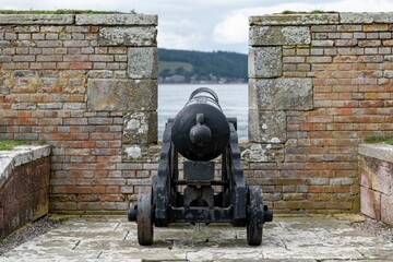 War cannon at barracks complex in historical Fort George behind a protective wall, Scotland