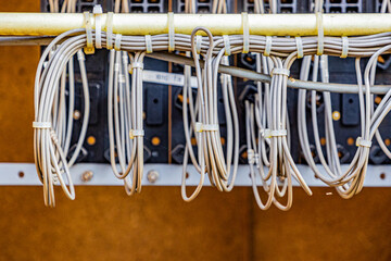 Close-up of wire in an electric installation in a disused control relay box of the old Iron Rhine Railway (IJzeren Rijn) white wires attached by a plastic cable tie. Middle Limburg, the Netherlands