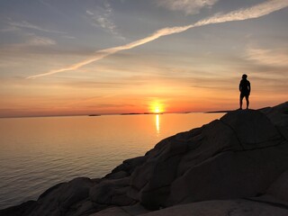 coucher de soleil avec une personne sur le côté droit qui regarde le paysage