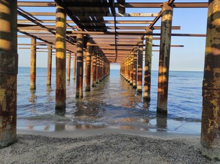 Abandoned rusty pier, dock at the coast