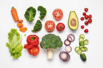 Fototapeta na wymiar Creative layout made of variety of vegetables for making salads. Carrots, lettuce, kale, tomato, cucumber, broccoli, avocado, red bell pepper, onion. White background, top view, copy space