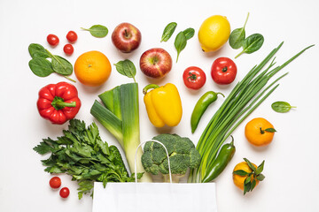 Paper bag full of vegetables and fruits on a white background. Top view, shopping and delivery concept
