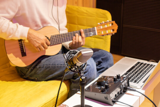 live music streaming and recording concept. asian music vlogger streaming a live video while playing acoustic guitar in home studio