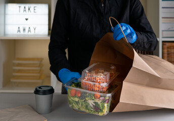 Food on plastic containers ready to take away on a paper bag. Food delivery