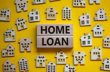 Wooden blocks form the words 'home loan', miniature wooden houses. Beautiful yellow background, copy space. Business concept.
