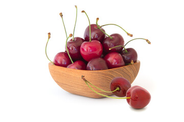 Ripe tasty cherries in the wood bowl isolated on white background