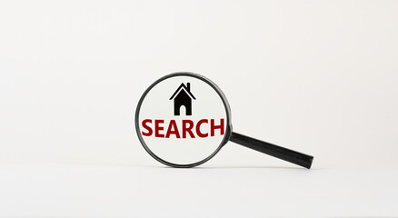 Magnifying glass with text 'search' and house icon on beautiful white background. Business concept, copy space.