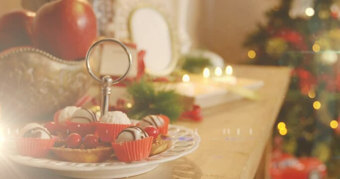 Animation of decorated christmas tree and table with christmas desserts