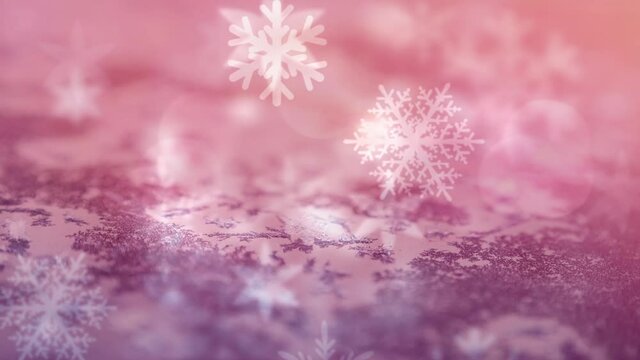 Animation of multiple snowflakes falling over pink surface