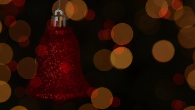 Animation of christmas red bell decoration and flickering lights on black background