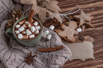 atmospheric Christmas composition, a cup of cocoa with marshmallows, gingerbread cookies, sweets, cinnamon.