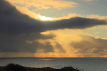 Sunrays shining through the clouds at sunrise over the Yorkshire coast, UK.