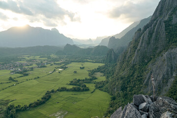 Naklejka premium Beautiful Sunset Views of Mountainous in Vang Vieng City which Popular for Tourists. View of Rice Fields Under the Mountains.