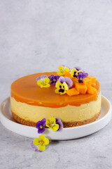 Delicious mango cheesecake topping with mango slices and edible flower view
