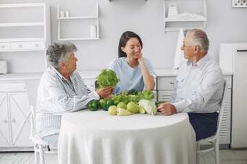 Family in a kitchen. Grandparents with granddaughter. Family made a salad