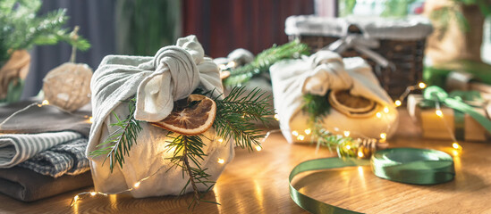 Christmas gifts. New year and gift wrapping, zero waste furoshiki, eco friendly gift wrapping in kraft paper on eco christmas background, eco christmas holiday concept, banner with eco decor