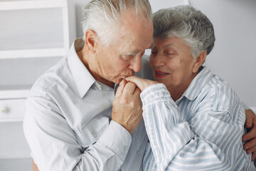 Old couple in a room. Grandparents at home. Woman in a whire whirt