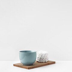 Blue mug and meringue cake on a white background. Eco-friendly and natural materials in decor and interior design, dessert. Copy space, mock up.