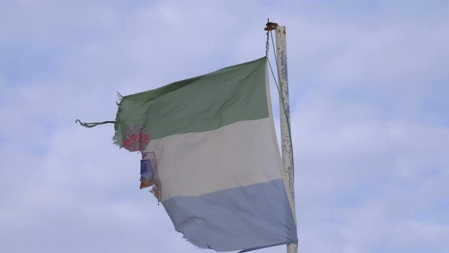 Destroyed andalucia flag waving in the wind in 4K
