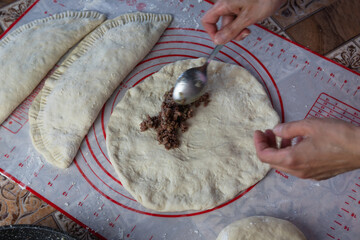 Close up of a woman's hands making dough for homemade bread, empanadas. female baker preparing...