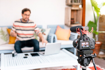 Camera screen showing a man pointing his computer screen. Focus on camera screen.