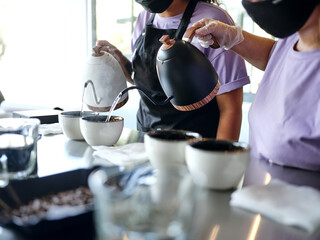 Coffee time - any time. Close up shot of process of coffee cupping. Hot water is poured onto freshly roasted and ground beans directly in cups. Selective focus. Horizontal shot