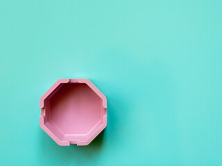 pink plastic ashtray on blue background