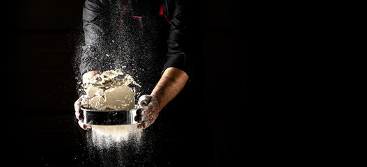 Powdery flour flying into air. chef hands with flour in a freeze motion of a cloud of flour midair. Hands kneading raw dough. Culinary, cooking, bakery concept