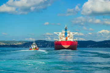 Giant freighter and coast guard boat passing through the Bosphorus Strait, Istanbul, Turkey....