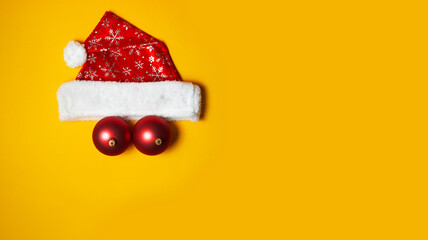Christmas hat and balls on the yellow background