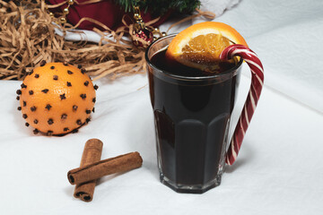 Close-up of a drink. A glass of warming drink with orange and caramel canes.