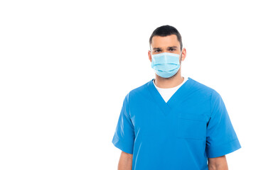 Nurse in medical mask and uniform looking at camera isolated on white