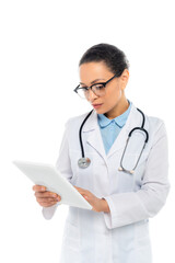 Fototapeta premium African american doctor in white coat and eyeglasses holding digital tablet isolated on white