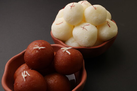 Famous Indian desserts rasgulla/ rosogulla/ roshogulla and gulab jamun/ gulabjam served in earthen bowl.