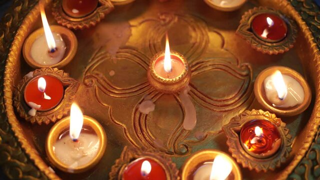 Macro shot showing colorful earthenware diya oil lamps with a little cotton wick to burn oil for light often used as decoration on the hindu festival of diwali showing the victory of good over evil