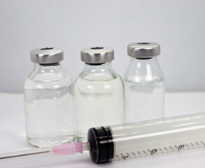 Vaccine vials and syringe on white background