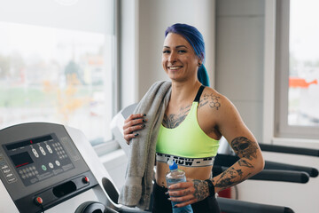 tattooed woman preparing for power lifting in gym
