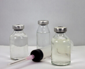 Vaccine vials and syringe on white background