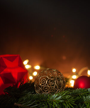 Stimmungsvolle Weihnachtsdekoration mit Kugeln und Stern vor dunklem Hintergrund