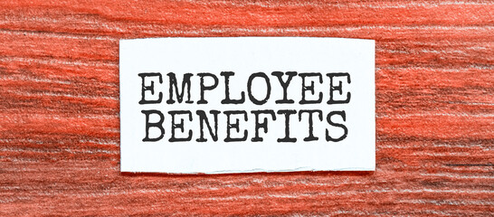 Employee Benefits text on the piece of paper on the red wood background
