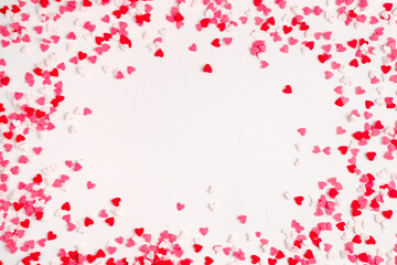 Lots of little red, pink and white hearts on a light background. Top view, with space to copy. The Concept Of Valentine's Day.