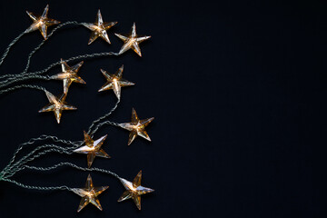 Top view of star shaped Christmas lights against black background with copy space