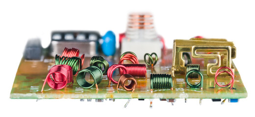 Colored wire winding of air core coils in circuit board on white background. Various red or green...