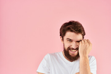 Man in white t-shirt gestures with hands emotions lifestyle cropped view pink background