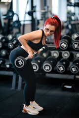 Fototapeta na wymiar Portrait of fitness woman doing barbell workout at gym