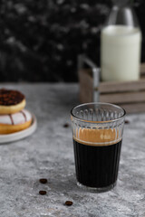 Black coffee in glass. Coffee and donuts